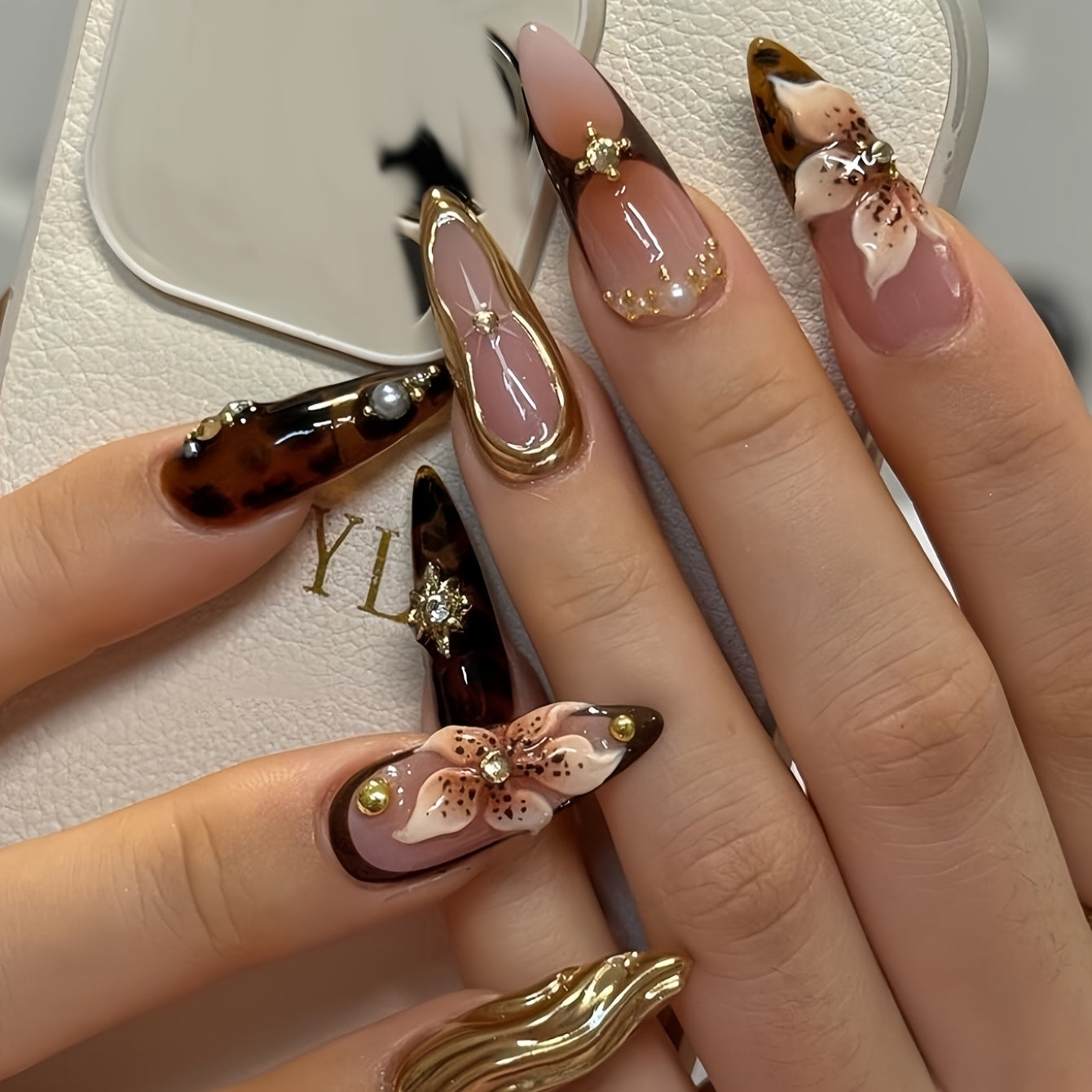 24pcs set of almond-shaped false nails with 3D three-dimensional wave texture and pure desire pearl flowers and sparkling rhinestones suitable for all women and girls. The box comes with nail files and jelly glue for easy app